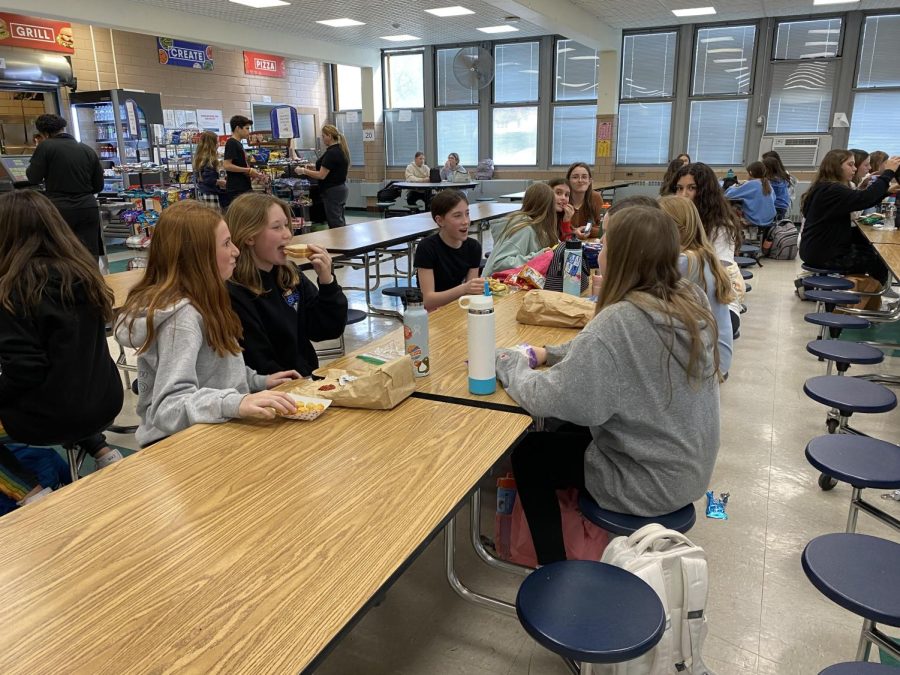 Seventh grade students sitting with friends in the EIS cafeteria.