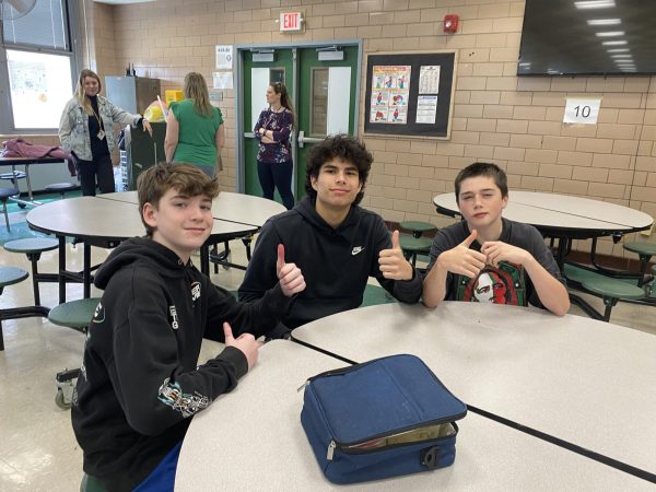 Eighth grader Jack McKeon likes the cookies; Christian Stepanov eats the nachos and pizza, and Adel Hamadallah buys cookies at the EIS cafeteria.