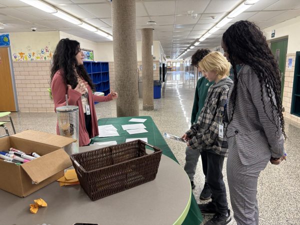 Student Assistance Counselor Ms. Melissa Wilson works with eighth graders Kobi Reece and Santi Gensler Canale to understand social media being misleading. Vice Principal Ms. Jada Cole looks on with them. 