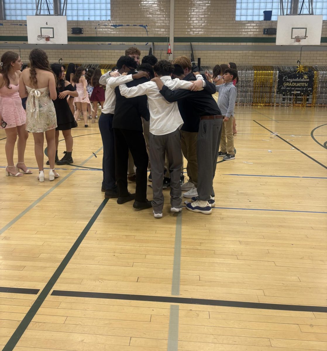 An eighth grade boy group hug on the dance floor of the event held on June 12 for the EIS graduates.